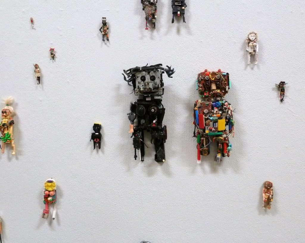 UusiX näyttelyn lähikuvaa. Kuvassa erilaisia robotteja seinällä.