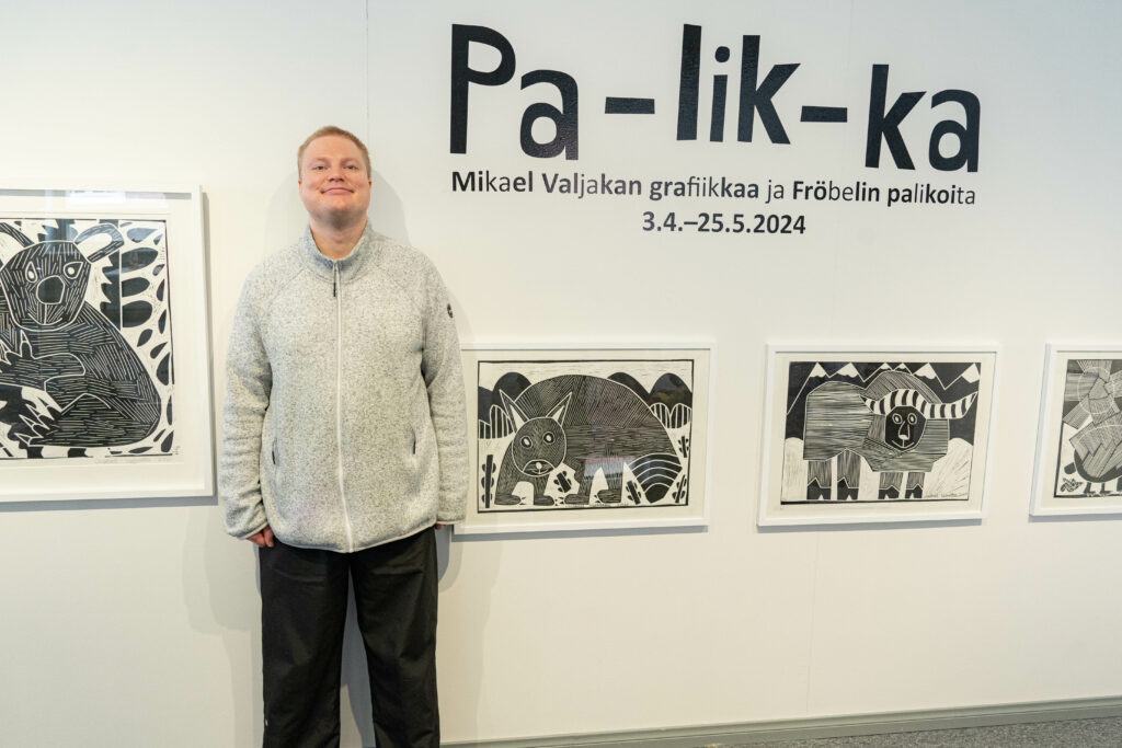 Näyttelyn taiteilija Mikael Valjakka teostensa luona Pa-lik-ka -näyttelyn avajaisissa.