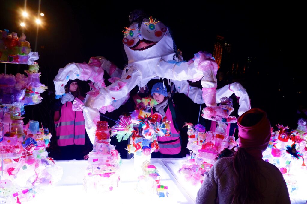 Kierrätysmuovista tehty Juhlat-teos osana Valoilmiö-festivaalia. Kuvassa valaistun juhlapöydän lisäksi Kristiina-jättiläisvalonukke. 