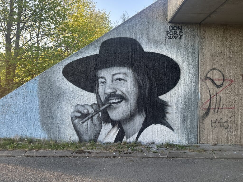 Irwin Goodmanin maalaus tunnelin seinällä, puita takana